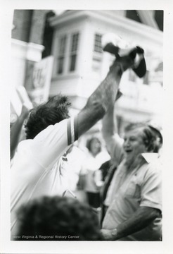 Two men with their arm raised dance during the first Annual Italian Heritage Festival, in Clarksburg, West Virginia.