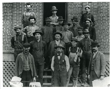 Group portrait of streetcar workers in front of a brick building in Clarksburg, West Virginia.