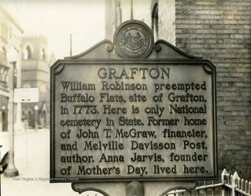 A close-up view of a Grafton Historic Marker, in Grafton, W. Va. 'Grafton: William Robinson preempted Buffalo Flats, site of Grafton, in 1773. Here is only National cemetery in State. Former home of John T. McGraw, financier, and Melville Davisson Post, author. Anna Jarvis, founder of Mother's Day, lived here.'