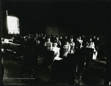 Students sitting in a classroom in Grafton, W. Va.  Division between the girls and boys in seating.