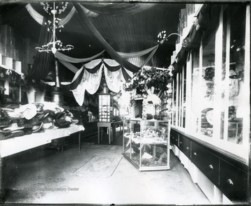Interior view of the Frank Ellis Store with women's hats on a display table in Grafton, W. Va.