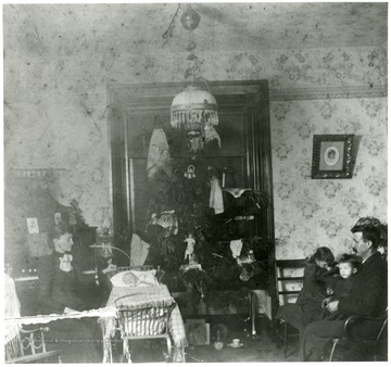Christmas in the Robinson Home on West Main Street in Grafton, W. Va.  Fannie E. and W.R. Loar, Madue, Grace, and Leslie gathered around the Christmas tree.