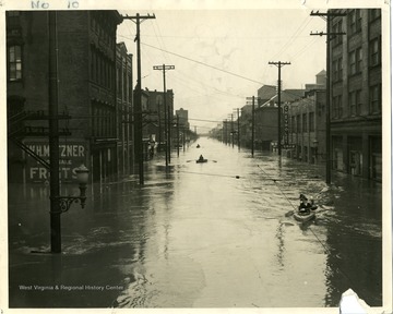 People are paddling boats in order to travel down Main Street in Wheeling, West Virginia during the flood of 1936.