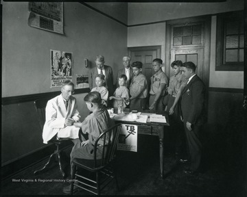 A doctor vaccinates young boys for TB.