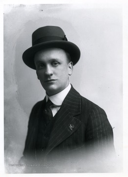 Man wearing a three-piece suit posing for a photograph.