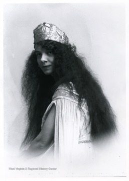 A woman with long curly hair is sitting.