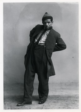 A male performer of the F. LaMonte Merry Makers with a pipe in his mouth.