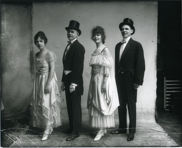Two women entertainers are standing in between two male entertainers.