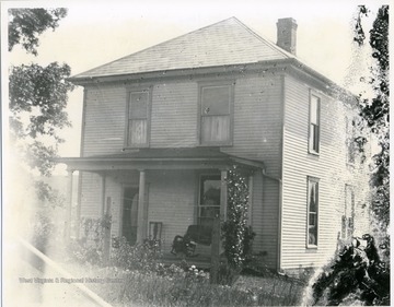The front of a two-story wooden house possibly in Helvetia, West Virginia is shown in this photograph. 