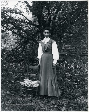 Women standing with a chair, tree in the background.  Helvetia, W. Va.