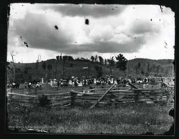 Townspeople are gathered at a cemetery on a rainy day in Helvetia, West Virginia.