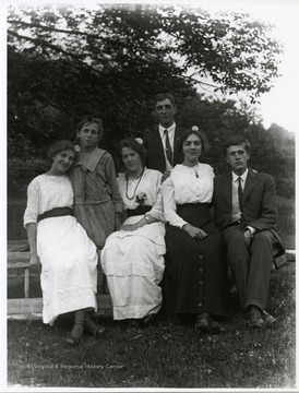 Two young gentlemen are posing with four ladies.
