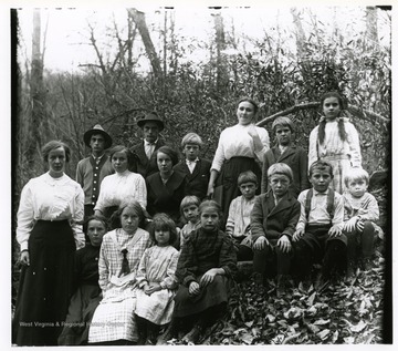Group portrait of children with two teachers taken outdoors.