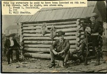 'This log structure is said to have been located at 5th Avenue and 9th Street. From left to right, men shown are 1) Frank L. Doolittle, 2) ???, and 3) Will Chaffin.'