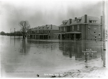 6th Avenue covered in water after the Huntington flood. Porches of homes are submerged.