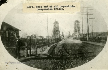 One young boy stands to the left of the beginning of the bridge.