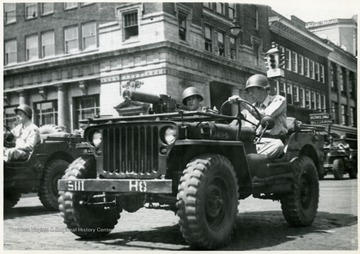 Soldiers driving a war vehicle during the Fourth of July parade, Huntington, W. Va.