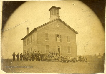 'Lewisburg Public School as erected in 1875, and school started in Fall of same year.  Life size of janitor peeping out of the upstairs window.'
