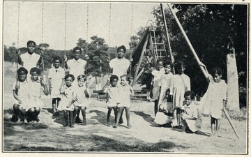Children of the West Virginia Colored Orphan's Home in Huntington, West Virginia are playing on a swingset.