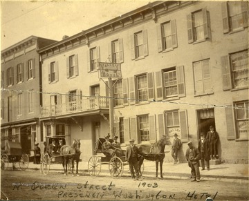 Horse drawn carriages going past the Valley Hotel 'presently Washington Hotel' on North Queen Street, Martinsburg, W. Va.