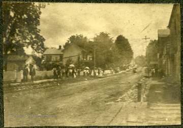People walking on the sidewalk of Church Hill, Lewisburg, W. Va. 'just after the corner stone layed.'