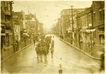 'Looking West on Third Street.'  Men in uniform walking in formation on Third Street.
