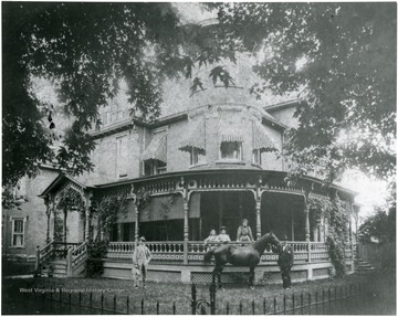 People and a horse are outside of the home.