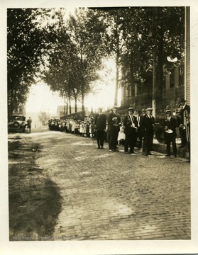 Gentlemen are participating in a parade in Thomas, West Virginia.