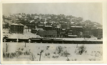 A train is going through the town of Thomas, West Virginia on a snowy day. 