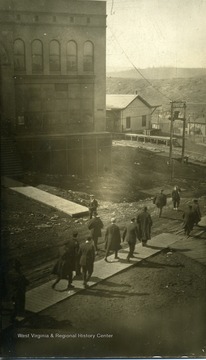 People are walking in front of Buckston and Landstreet Store and the Railroad Depot in Thomas, West Virginia.