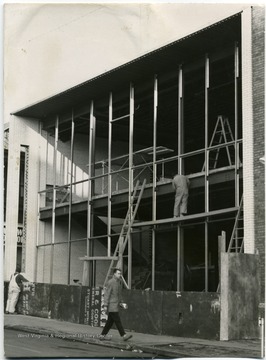 Two men work on the building.