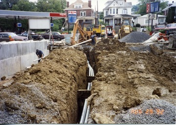 Workers can be seen constructing South Park bridge in Morgantown, W. Va. Running pipe throught trenches. 