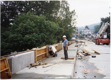 Construction in progress of South Park Bridge. Three workers can be seen on bridge. 