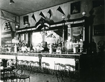 'Frank Dent's Drug Store? Maybe? or Moore Parrot McVickers'. 'Harry Selby on left, original in WVGP.' Men standing behind the counter.