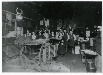 Employees of the Morgantown Printing and Binding business pose for a group portrait. The business was located at the corner of Pleasant and Chestnut Streets in Morgantown, West Virginia.