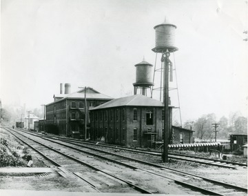 Glass factory located near Rail tracks in Morgantown, W. Va. Person walking down the railroad tracks. 