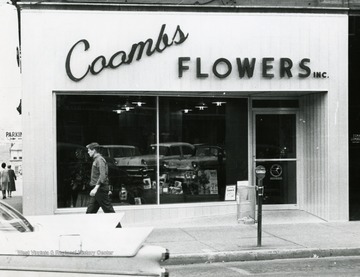 A man is walking in front of Coombs Flowers Shop, in Morgantown, West Virginia.