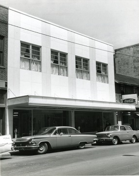 O. J. Morrison's shop in Morgantown, W. Va., after refacing exterior of building. Automobiles parked at meters along the street. 