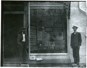 Two men stand beside the window display.