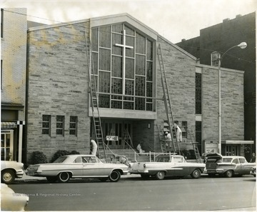 Men working on the windows and railings on the outside of the Baptist Church on High Street, Morgantown, W. Va.