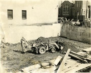 Men working on the new city library location, one is on a backhoe, Morgantown, W. Va.