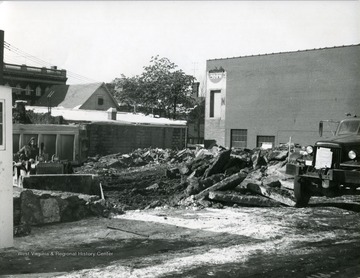 Constructing Parking lot located near the High Street, Fayette Street, and Chestnut Street intersections. Worker on bulldozer removing concrete and dirt. 