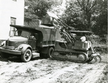 Bulldozer loading Dump Truck with debris from construction site of a Morgantown, W. Va., city parking lot. 