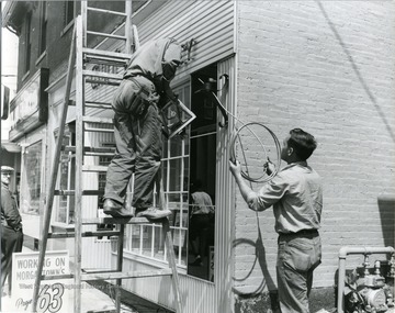 Workers seen running a light fixture on a building located on High Street in Morgantown, W. Va. 
