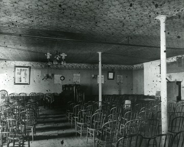 Chairs sit in rows at unknown Church located in Morgantown, W. Va.  Piano seen in front of chairs. 