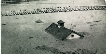 'School House Afloat on the Ohio River, Flood of March 1907, passing under the bridge at Wheeling, W. Va. (This school building floated from Warrenton, Ohio, to Sistersville, W. Va., a distance of over 100 miles.)'