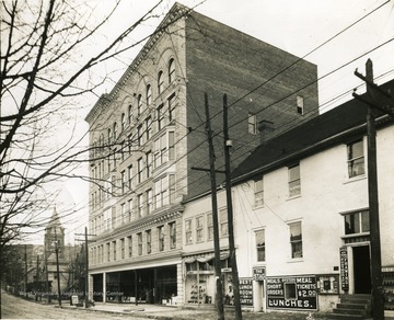 'High Street - corner of Fayette Street and High Street. Six story stone building is the old Strand Theater building, which burned down in 1927.'