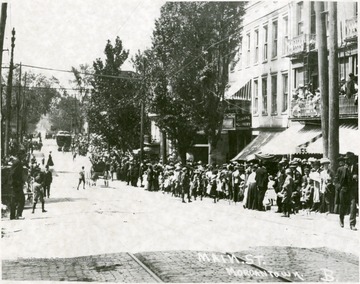 Large crowd of people gathered on the sidewalk of High Street, Morgantown, W. Va.