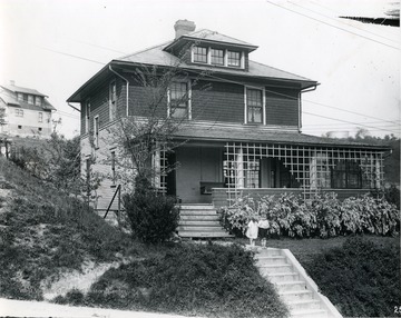 Front view of the residence of H. B. Allen in Morgantown, W. Va. Two children stand in front of the house on the walk way above the steps. Another house can be seen behind this residence. 