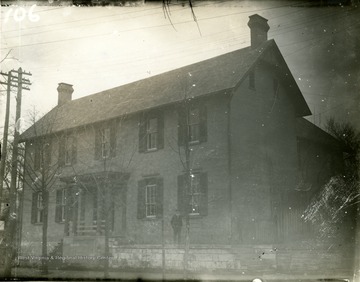 A man stands in front of the J. H. Hoffman house located on High Street in Morgantown, W. Va. 